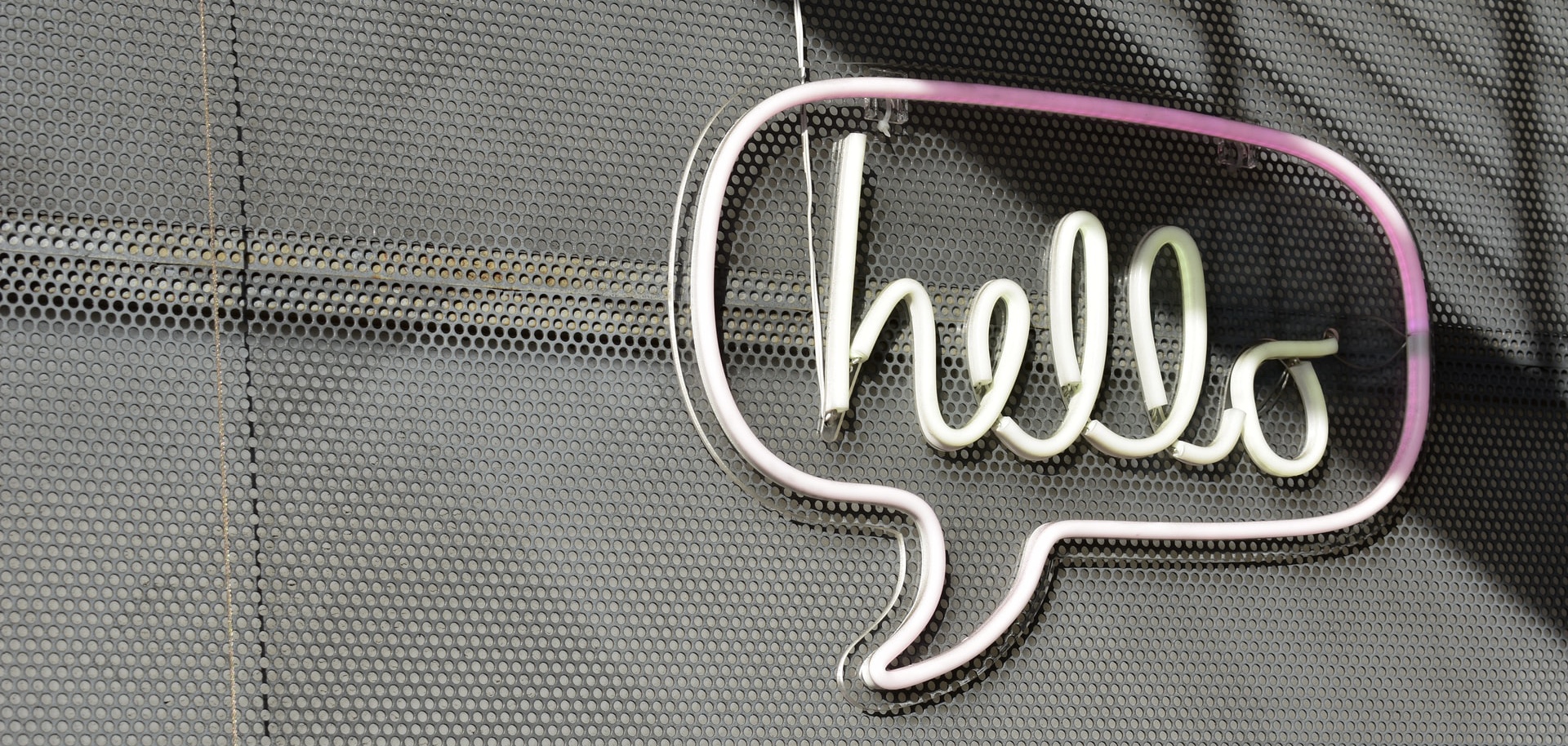 Neonfarbene Sprechblase mit Schriftzug "hello"